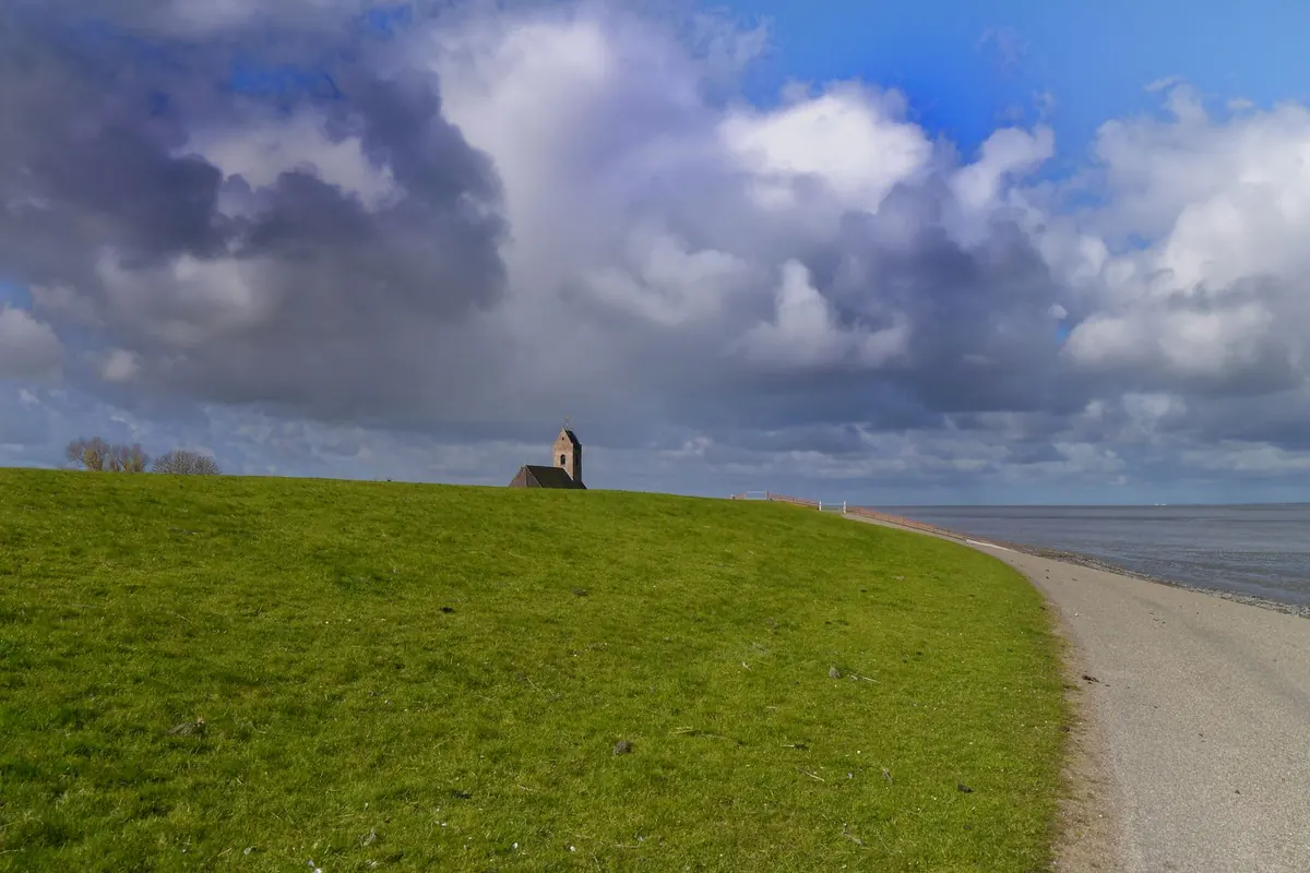 Beautiful view of Wierum Church against dramatic skies along the Friesland coast.