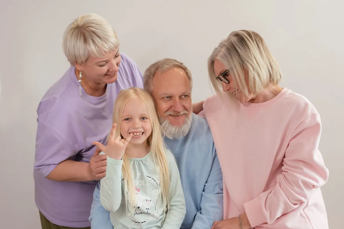 A joyful multigenerational family poses and smiles together indoors, showcasing love and togetherness.