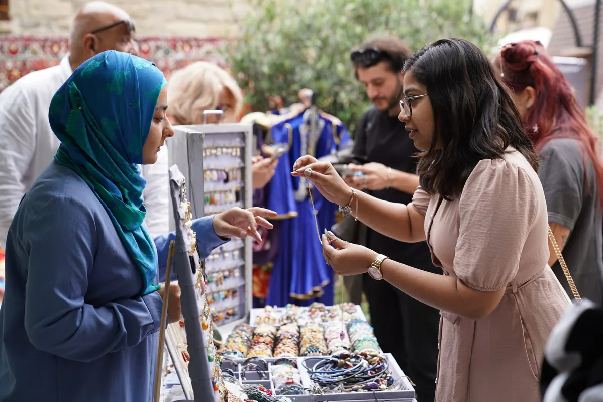Women engaging in vibrant jewelry trading at an outdoor market, capturing cultural interaction.